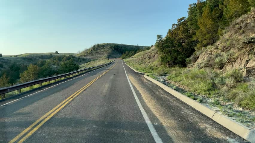 Driving through the badlands hills and mountains in Theodore Roosevelt National Park in North Dakota.