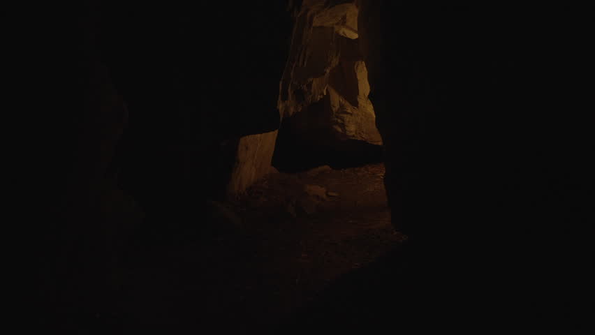Young Man Discovering Stone Cave Outdoors at Night Holding Torchlight Royalty-Free Stock Footage #1105774521