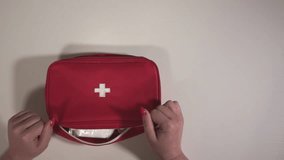 view from above. a woman opens a first aid kit. first aid kit and pills. close-up. slow motion video. High-quality shooting in Full HD