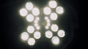 POV view patient on bed looking to bright surgical lights in dark hospital operating room close up. Focusing in and out to white surgery room lights. Medical equipment consept. - Powered by Shutterstock - Get 15% off with code: PIKWIZARD15