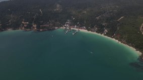 Sunny island drone flight: pier, beach, village, blue ocean, green landscape, cambodia Koh Rong island