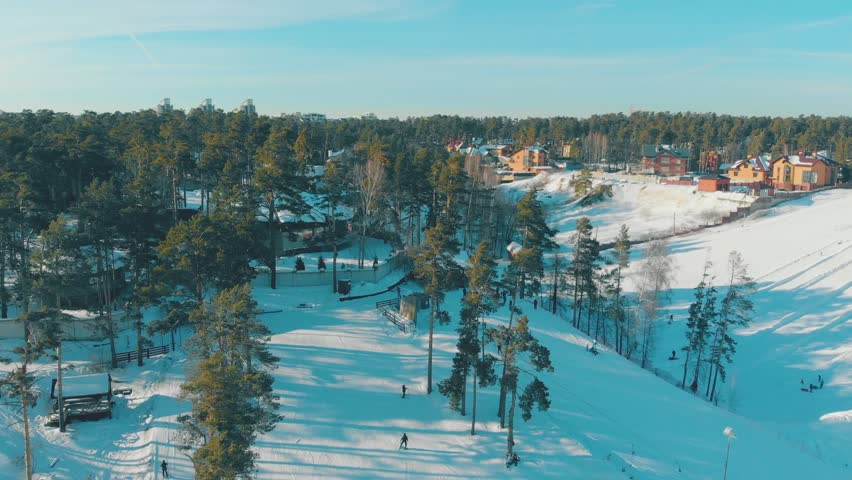 pictorial winter resort with cozy ski tracks on snowy mountains covered with old pines bird eye view