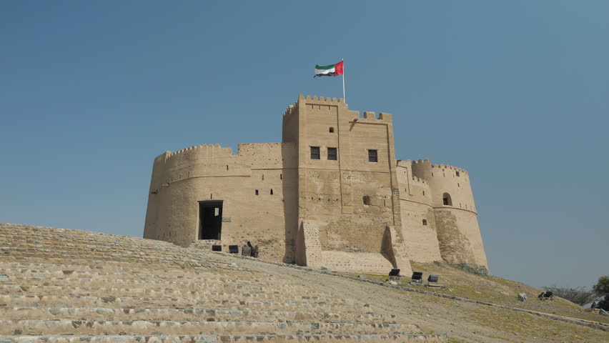 Fujairah fort with the flag of the United Arab Emirates waving in the wind. Royalty-Free Stock Footage #1105783817