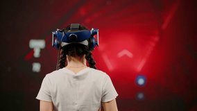 The child wearing VR headset plays game. The little girl use tracking controllers in her hands, moves actively immersing herself in modern game. Behind girl there is screen with blur background image - Powered by Shutterstock - Get 15% off with code: PIKWIZARD15