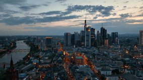 Dolly Flight through Frankfurt am Main, Germany. Skyline. New Skyscrapers. Urban Canyon in Sunset or Sunrise Light. Aerial Pedestal in Establishing Night Drone Shot. Glowing street lights