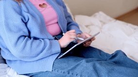 Teenage girl in headphones doing online tasks on modern tablet using pen focused schoolgirl in glasses listening to music while studying remotely from home - Powered by Shutterstock - Get 15% off with code: PIKWIZARD15