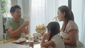 asian happy family spend time have breakfast or dinner on table together at sunlight.Little kid daughter enjoy eat yummy food with father,asian mother.asia family day meet talk at home - Powered by Shutterstock - Get 15% off with code: PIKWIZARD15