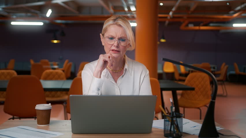 Unhappy frustrated workaholic businesswoman working at project deadline overtime. Annoyed overwhelmed sad CEO boss in loft empty office 4K. Tired mature woman 50s overworked on computer late at office Royalty-Free Stock Footage #1105800205