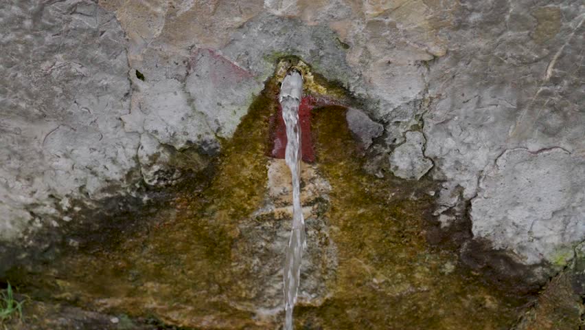 Natural spring pure source with a stone rocky base. Slow motion