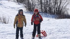 A boy and a girl walking together and then riding sled