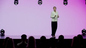 Caucasian woman female speaker presenting on the stage during conference. Presenting ideas against bright pink background - Powered by Shutterstock - Get 15% off with code: PIKWIZARD15