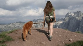 girl with a red dog on top of a mountain. a girl with a Nova Scotia retriever on a warm sunny day comes to the edge of the mountain and photographs the surrounding landscape.  - Powered by Shutterstock - Get 15% off with code: PIKWIZARD15