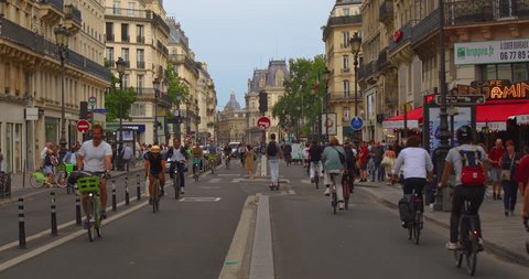 France, Paris, 19 June 2023: Rue Rivoli is one of the longest and most famous in Paris, a natural extension of the Champs-Elysees to the east from Place de la Concorde. Cyclists and crowds of people : vidéo de stock éditoriale
