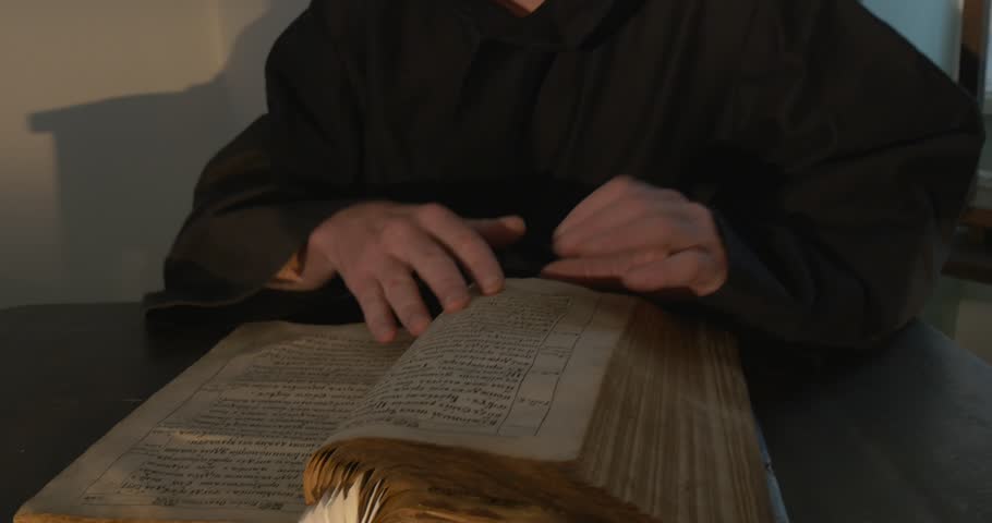 Monk, man with beard and mustache in Black Clothes, Black Hood, Leafing Through the Book Royalty-Free Stock Footage #11058107