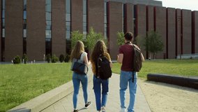 Back view of three caucasian students walking through university campus. Shot with RED helium camera in 8K.   - Powered by Shutterstock - Get 15% off with code: PIKWIZARD15
