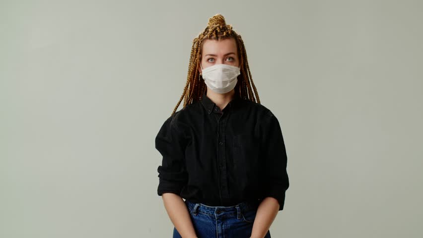 A young girl removes a protective mask from her face. The concept of health and protection against the virus.
