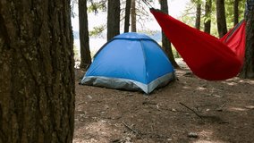 Nature's Tranquility: Camping in the Forest with a Woman Serenely Sleeping on a Red Hammock, Immersed in 4K Resolution Video