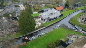 Giethoorn village - Venice of the Netherlands. Flying around canal. Boat is passing by
