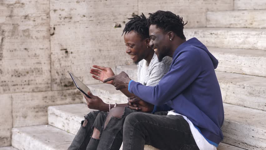 Portrait of two happy young black men using tablet to look at photos | Shutterstock HD Video #1105826803