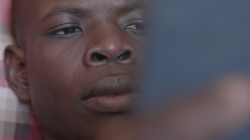 Close up portrait of focused young black man watching a football match on tablet | Shutterstock HD Video #1105826911