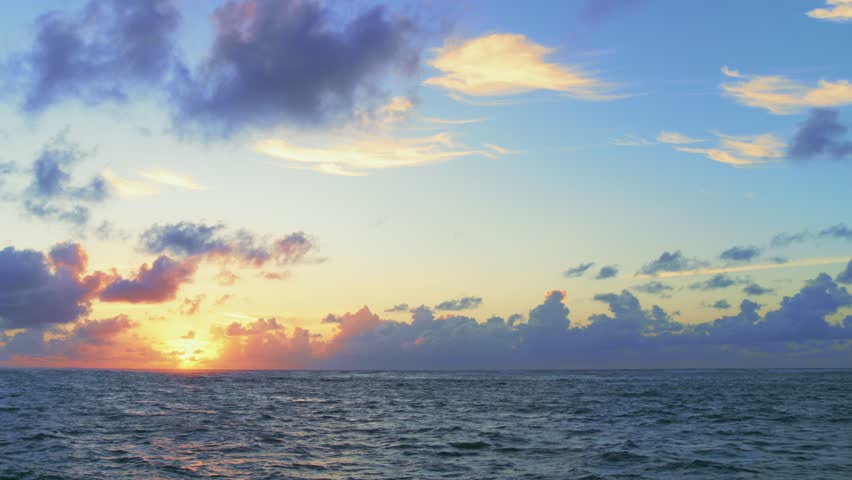 Sea dawn of nature in summer tropical morning. Sea waves with a reflection of the golden hue of the sun. Rippling water with sun rays. Deep blue ocean under an orange-blue sky. Twilight over the sea. Royalty-Free Stock Footage #1105829297