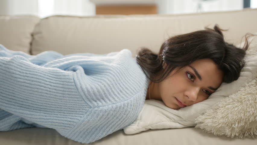 Overloaded exhausted young brunette woman in casual sweater came home after work, felt down on sofa, feeling like squeezed lemon. Tired overworked person hard day, lack of energy after party concept | Shutterstock HD Video #1105832169