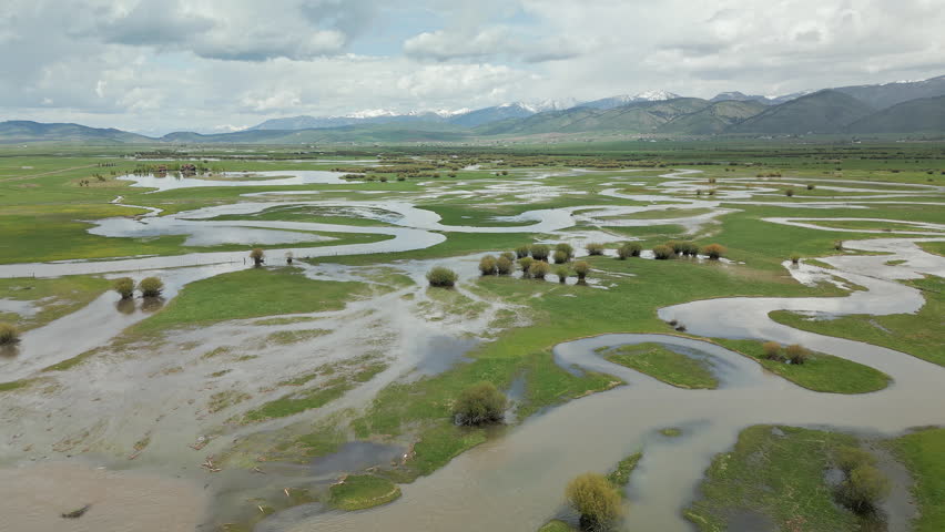 Aerial view flying over the Salt River winding through pastures as it floods the fields in Wyoming.