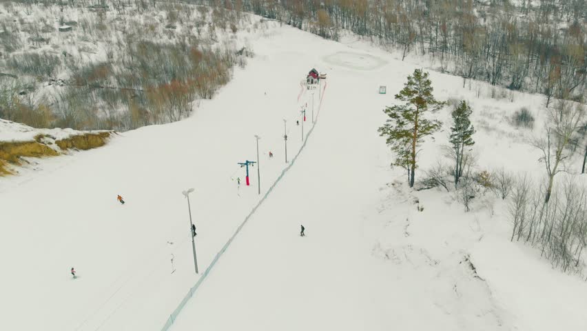 pictorial landscape with ski trail and surface lift poma on mountain slope at winter wood upper view