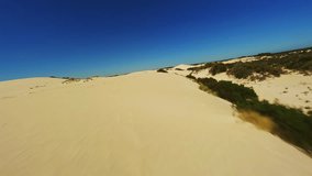 Sand dunes in the desert during the day, drone video