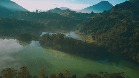 Aerial footage in the morning showing the stunning lake with a background of Mount Sindoro in the distance, which is one of Indonesia's tourism icons
