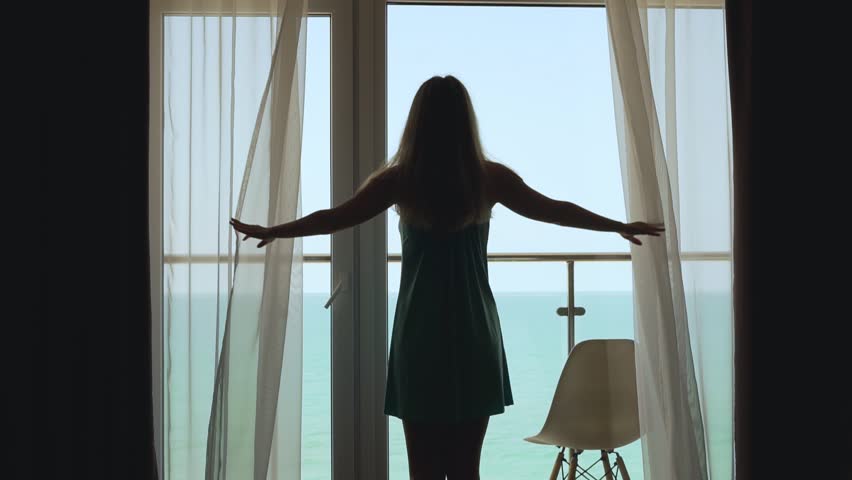 Girl Opens the Transparent Curtains and Goes Out to the Terrace to Admire the Beautiful Ocean View in the Morning. Travel, Summer Holidays in Luxury Resort with Sea View.