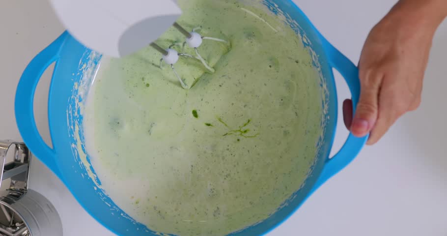 Woman mixing spinach with dough for healthy bakery, top view