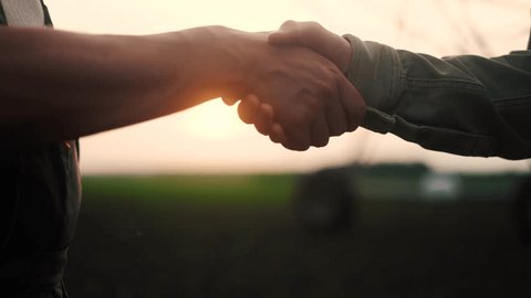 farmers handshake business contract. two farmers at sunset with corn irrigation plant in the background shaking hands. agriculture irrigation business concept. farmers handshake lifestyle วิดีโอสต็อก