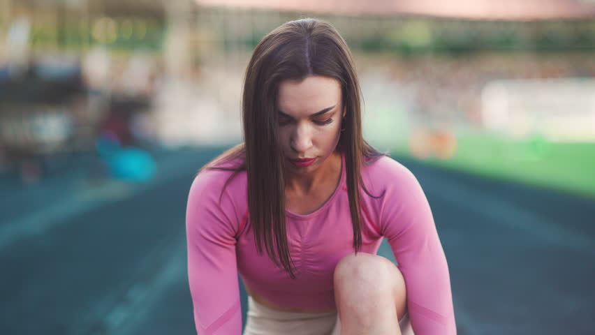 Young motivated girl is preparing to run in park in summer, heathy lifestyle, sport conception. Portrait of a girl runner before the race