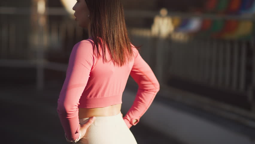Girl athlete take off her t-shirt before training. Portrait of a pretty girl runner at the stadium. Sport and healthy lifestyle concept.