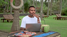 African american man work macbook. Afro guy sit outside palm tree cafe. Busy male use pc computer. Person rest open air park. Freelancer type black laptop. Hipster think over job. Digital nomad study. - Powered by Shutterstock - Get 15% off with code: PIKWIZARD15