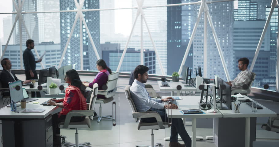 Team of Talented Young Indian Professionals Working in a Business Research and Development Agency. Desktop Computer Screens Showing Analytical Data, Research Reports and Diagrams