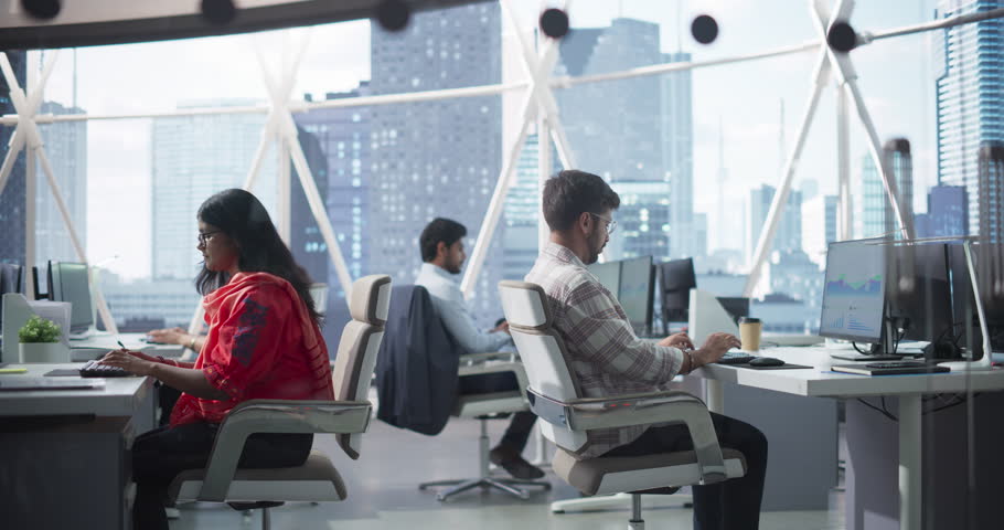 Team of Talented Young Indian Professionals Working in a Corporate Banking Agency. Financial Analysts and Managers Working on Computers in a South Asian Business Office with Scenic City View