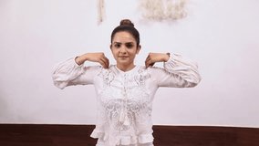 Stock video of fit woman in white outfit performing Shoulder socket rotation exercise.

