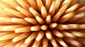 Macro video shot with a probe lens captures the intricate details of a toothpick's texture, revealing its wood grain, delicate fibers, and sharp point, showcasing the beauty. Wood background. 4K UHD
