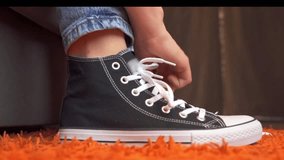 teenage girls tie their shoelaces on classic sneakers