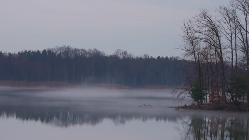 Panning shot of Lake on a misty fall morning