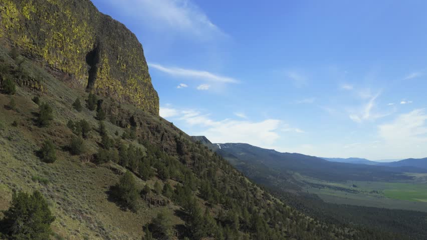 Lush Green Slope Of Abert Rim - Majestic Landmark In Lake County, Oregon With Breathtaking Scenery. aerial descend