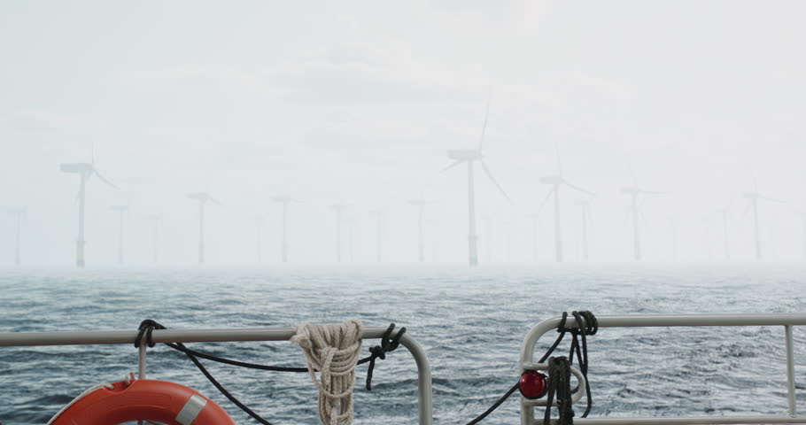 Maintenance engineer checking the data on tablet, approaching offshore wind turbine farm on a service vessel. Portrait of skilled professional preparing to work at high altitude Royalty-Free Stock Footage #1105877331