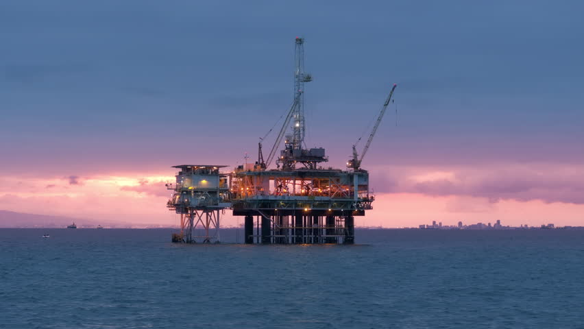 Marvel of engineering in the Pacific Ocean. Offshore oil drilling rig at dawn. Aerial view of modern drilling rig, extracting oil, gas, floating on water. High quality 4k footage