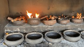 A fire is lit in a roasting stove using pots and kindling. video