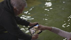 video on tablet. an elderly coach, sitting on a chair, shows the athlete a video on the tablet. close-up. canoeing. High-quality FullHD video recording