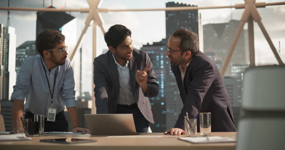 Cinematic Footage of a Successful Indian CEO Making a Presentation on a Laptop to a Board of Directors During a Corporate Meeting. South Asian Business Partners Discussing International Markets