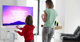 Mother and daughter are dancing and playing TV video games