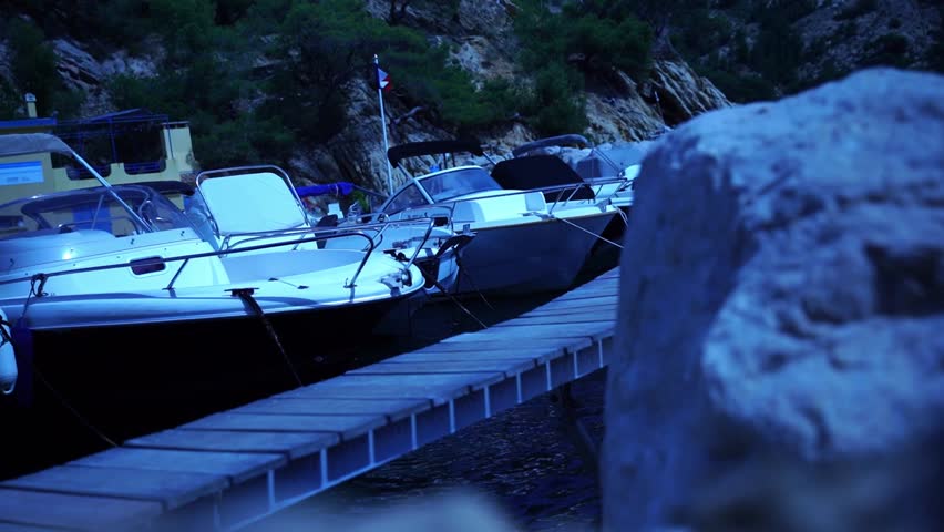 Boats for hire in France at a small port with a rocky coast